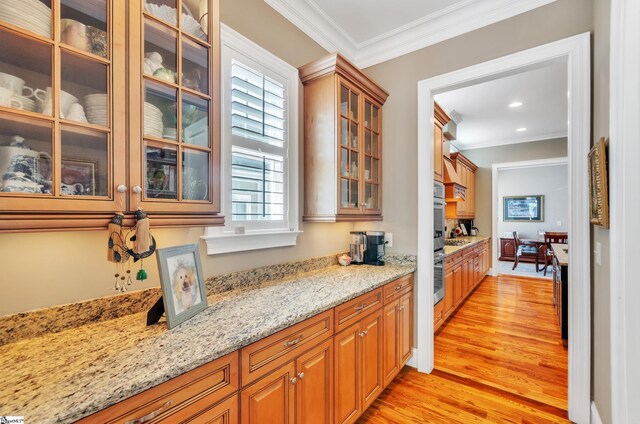 kitchen featuring ornamental molding, plenty of natural light, and light hardwood / wood-style floors