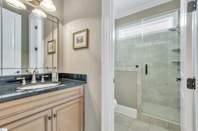 bathroom featuring toilet, walk in shower, tile patterned floors, crown molding, and vanity