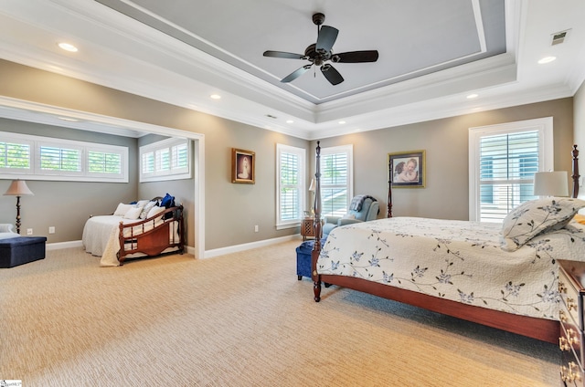 carpeted bedroom featuring ceiling fan, a raised ceiling, and ornamental molding