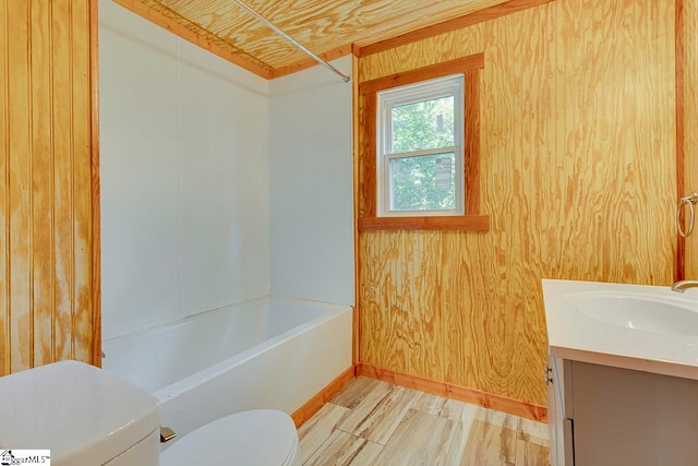 full bathroom featuring vanity, toilet, tub / shower combination, and wooden walls