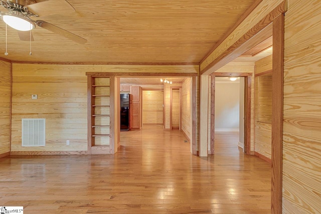 unfurnished room with wood ceiling, hardwood / wood-style flooring, ceiling fan, and wooden walls