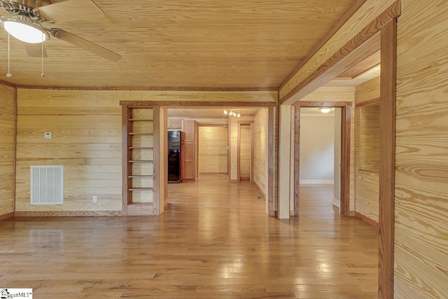 interior space featuring light wood finished floors, wooden ceiling, visible vents, and wooden walls