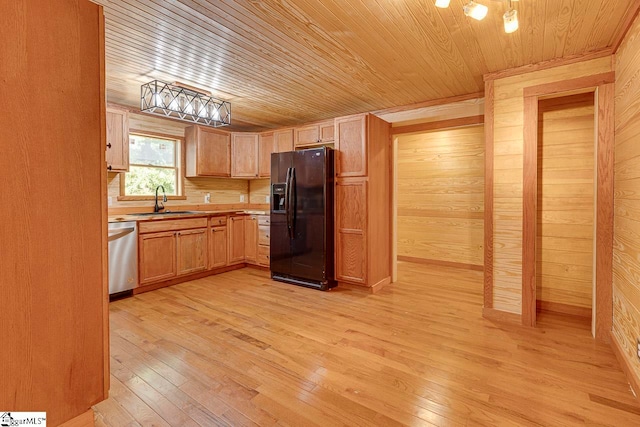 kitchen featuring dishwasher, wooden walls, light hardwood / wood-style flooring, sink, and black refrigerator with ice dispenser