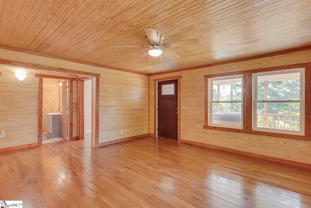 empty room featuring wood-type flooring, ceiling fan, wooden walls, and wooden ceiling