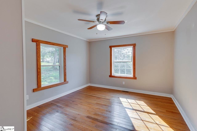 unfurnished room with light wood-type flooring, ceiling fan, a wealth of natural light, and ornamental molding