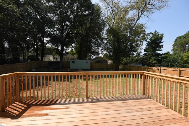 wooden deck with a lawn and a storage shed