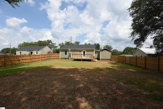 back of house featuring a wooden deck and a yard