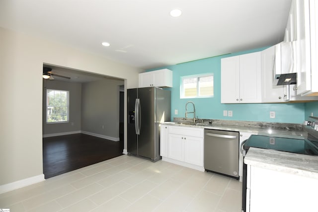 kitchen with appliances with stainless steel finishes, plenty of natural light, light tile patterned floors, and sink