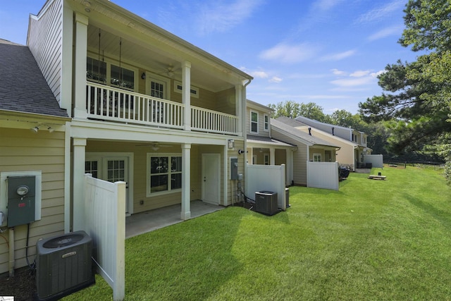 back of property with a yard, central AC unit, ceiling fan, and fence