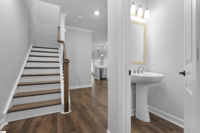 bathroom featuring a sink, ornamental molding, wood finished floors, and baseboards