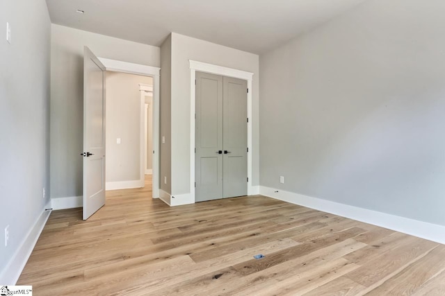 unfurnished bedroom with light hardwood / wood-style flooring and a closet