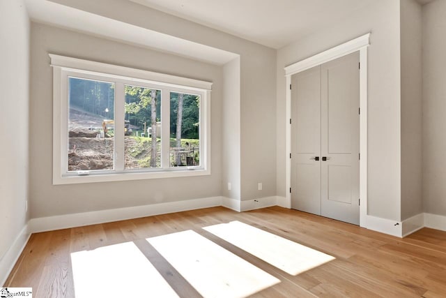 unfurnished bedroom with a closet and light hardwood / wood-style flooring