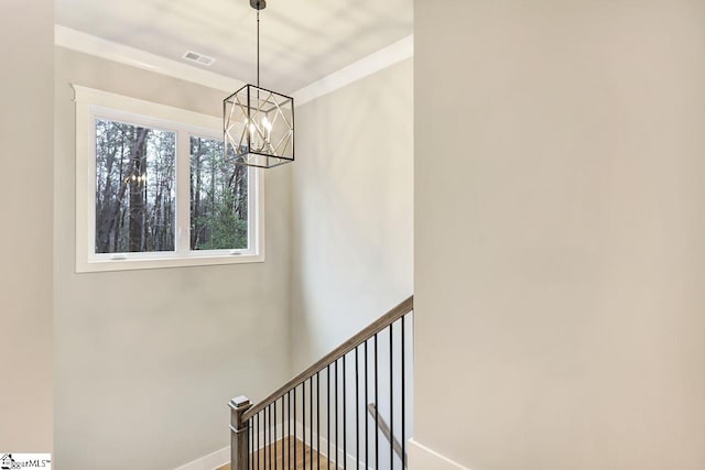 staircase with a notable chandelier