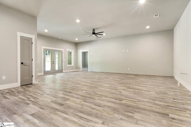 unfurnished living room with french doors, ceiling fan, and light hardwood / wood-style floors