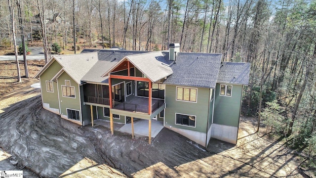 rear view of property featuring a sunroom