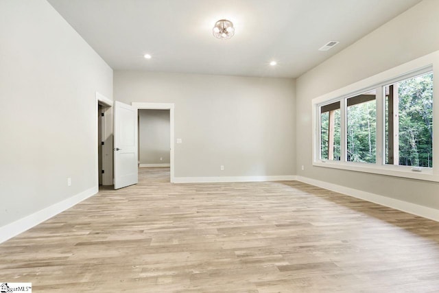 spare room with light wood-type flooring and plenty of natural light