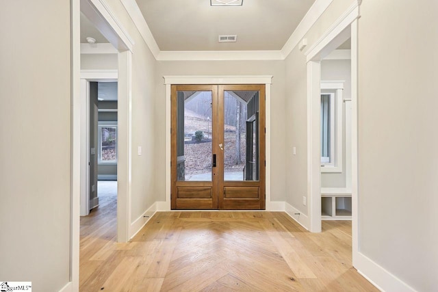 entrance foyer with light parquet floors, crown molding, and french doors