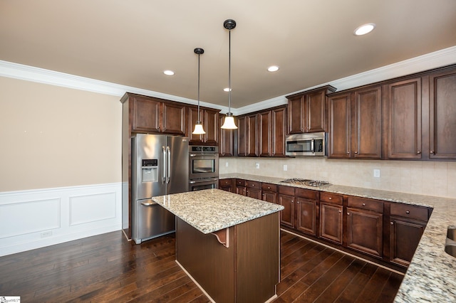 kitchen with hanging light fixtures, appliances with stainless steel finishes, dark hardwood / wood-style flooring, and tasteful backsplash