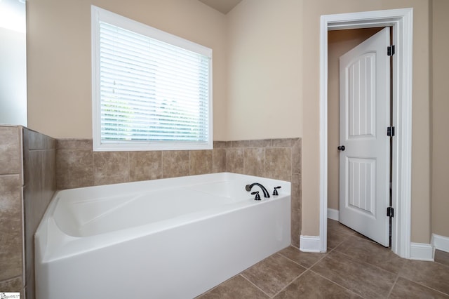 bathroom with a tub to relax in and tile patterned flooring