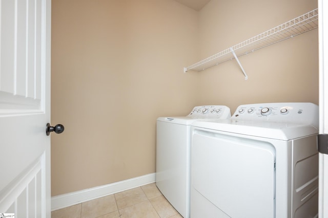 washroom featuring washer and dryer and light tile patterned flooring