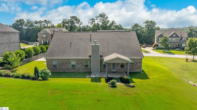 rear view of property with a lawn