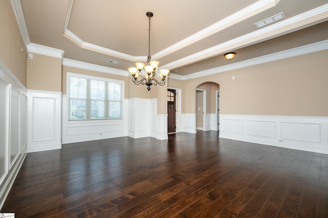 unfurnished room with a raised ceiling, ornamental molding, dark hardwood / wood-style flooring, and a notable chandelier