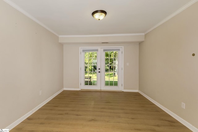 spare room featuring crown molding, french doors, and light hardwood / wood-style floors