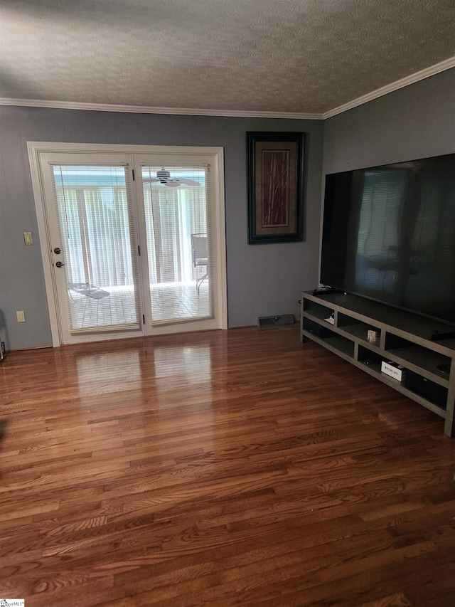 unfurnished living room featuring crown molding, dark wood-type flooring, and a textured ceiling