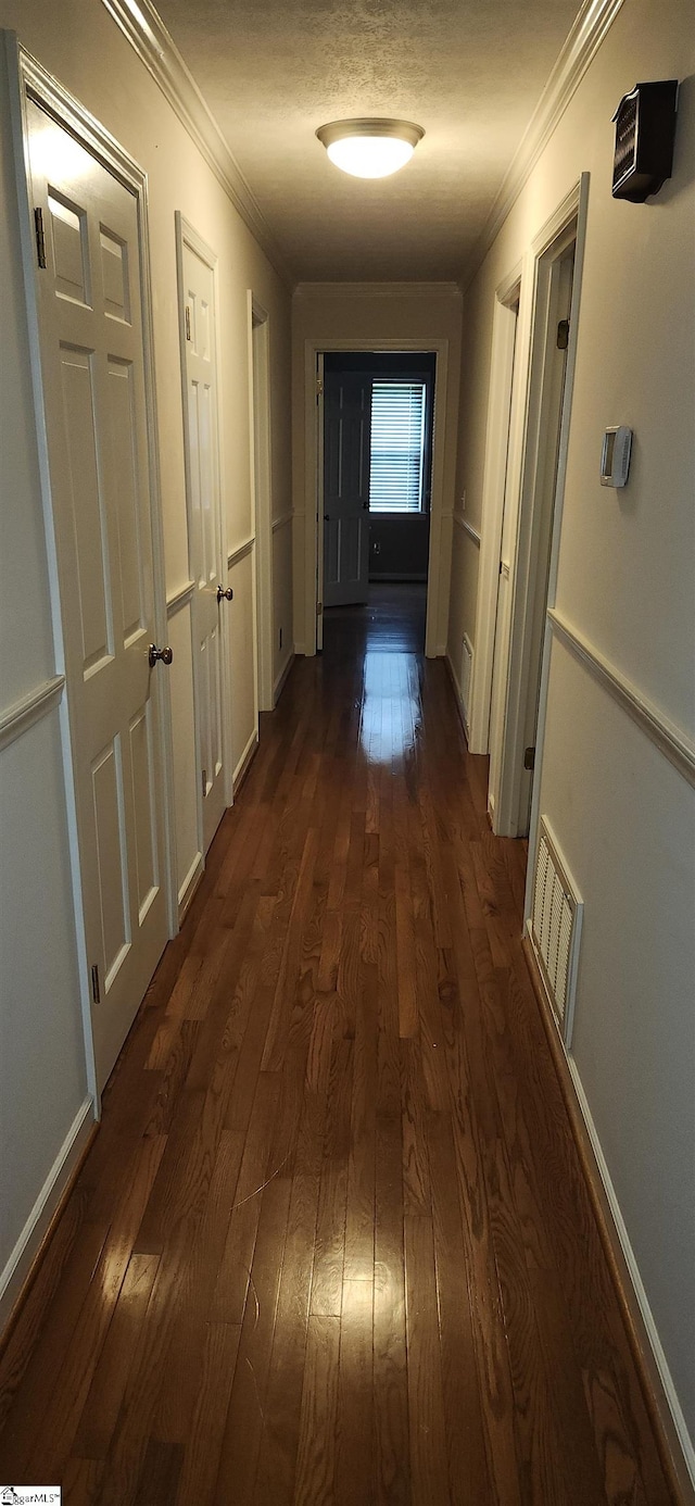 hall featuring ornamental molding and dark hardwood / wood-style floors