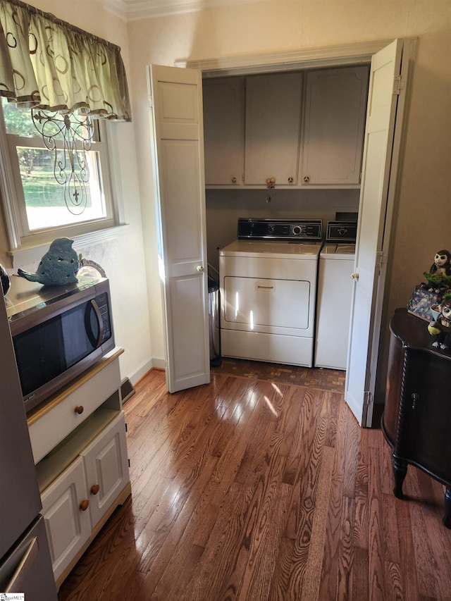 laundry room featuring ornamental molding, independent washer and dryer, cabinets, and dark hardwood / wood-style floors