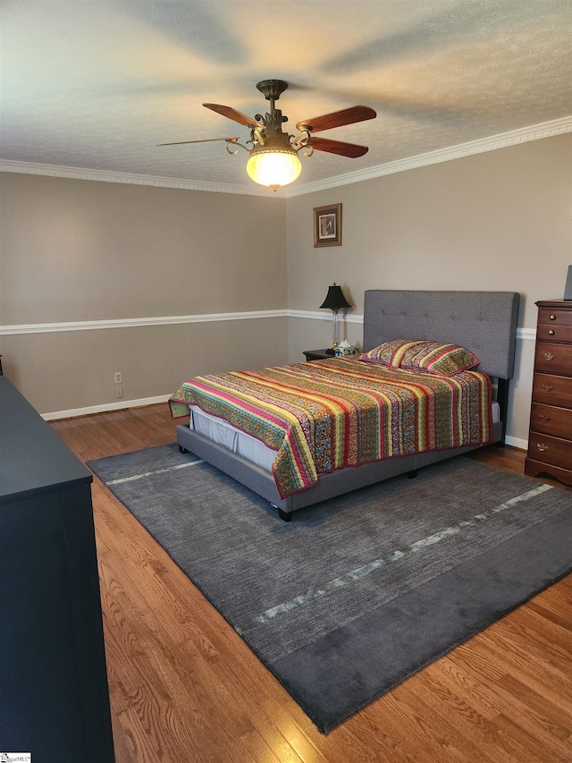 bedroom featuring ceiling fan, hardwood / wood-style flooring, and ornamental molding