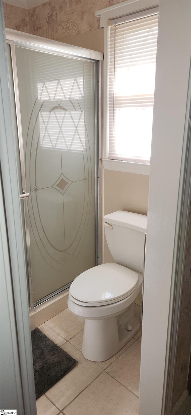 bathroom featuring toilet, walk in shower, and tile patterned floors