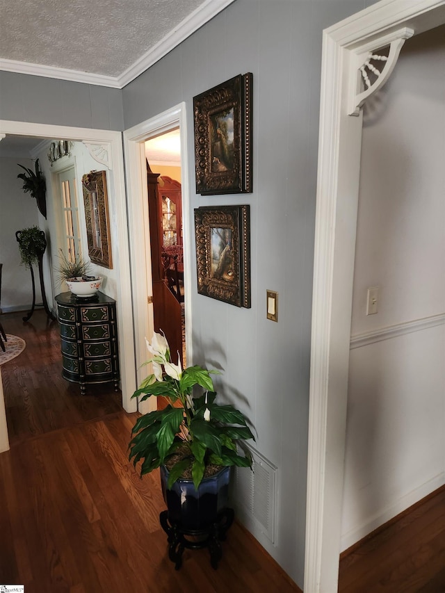 hallway featuring dark hardwood / wood-style flooring, crown molding, and a textured ceiling