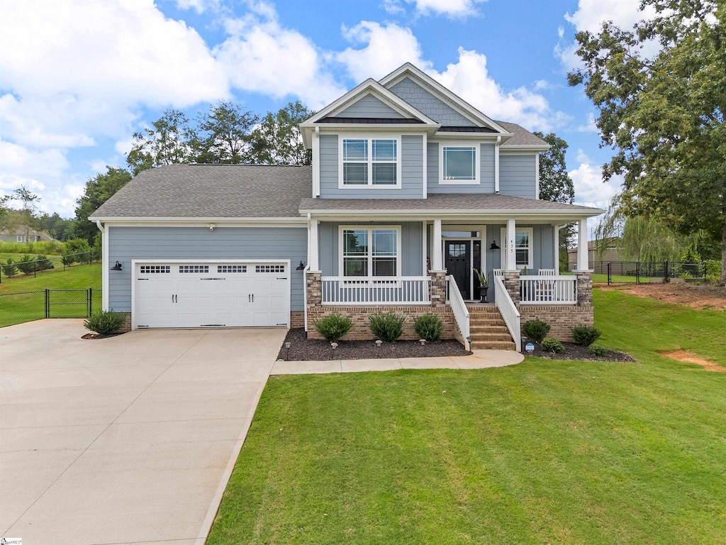 craftsman house featuring a garage, a front lawn, and covered porch