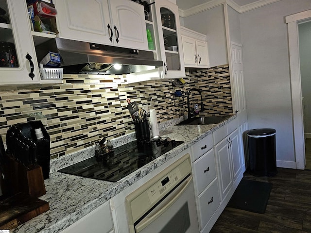 kitchen featuring dark hardwood / wood-style flooring, oven, white cabinetry, and sink