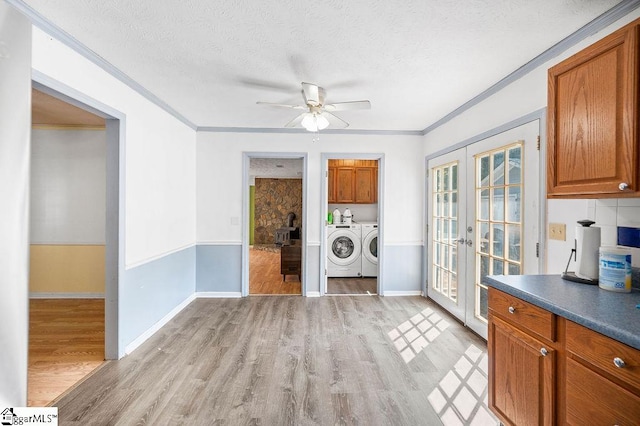 unfurnished dining area featuring french doors, light hardwood / wood-style floors, independent washer and dryer, ceiling fan, and a textured ceiling