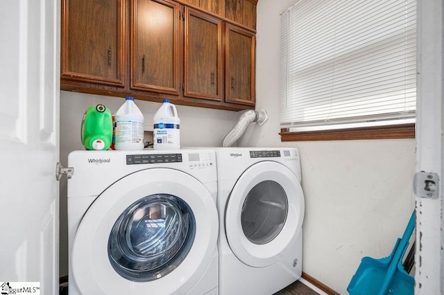 clothes washing area with cabinets and washer and clothes dryer