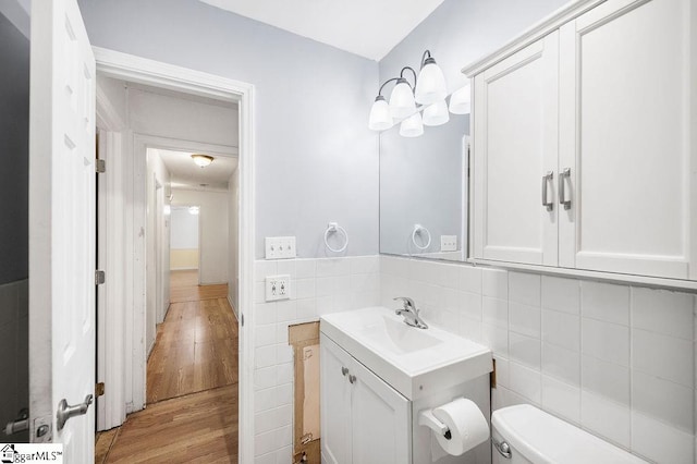 bathroom featuring vanity, toilet, tile walls, and wood-type flooring