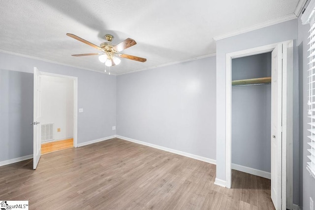 unfurnished bedroom with ceiling fan, ornamental molding, and light hardwood / wood-style floors