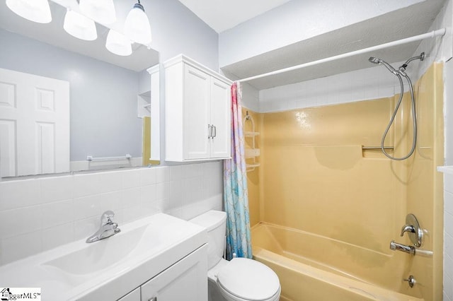 full bathroom featuring toilet, vanity, shower / bath combo with shower curtain, decorative backsplash, and tile walls