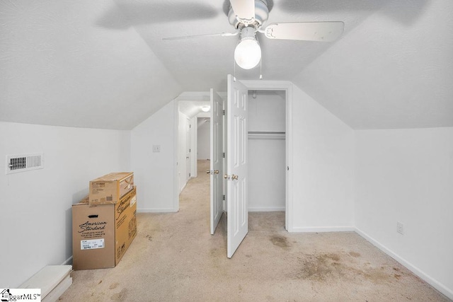 bonus room with lofted ceiling, ceiling fan, light carpet, and a textured ceiling