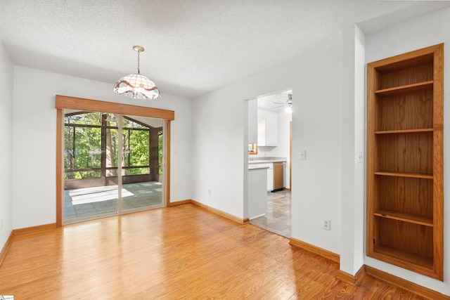 unfurnished room featuring a textured ceiling and light hardwood / wood-style floors