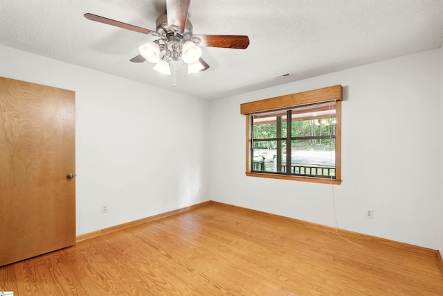 spare room with a textured ceiling, ceiling fan, and hardwood / wood-style flooring