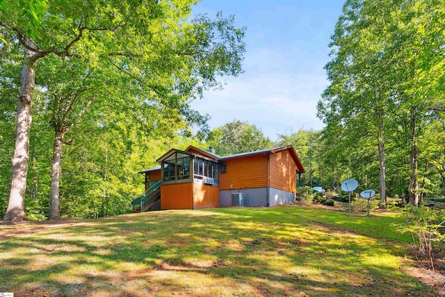 view of home's exterior featuring a lawn and central AC unit