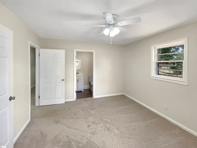 unfurnished bedroom featuring ensuite bath, carpet floors, and ceiling fan