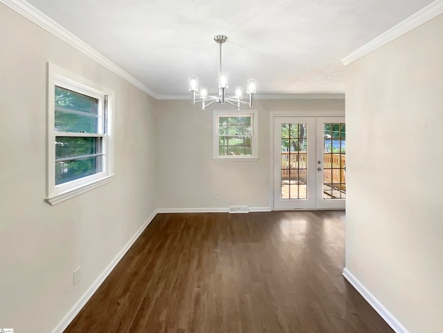 unfurnished dining area with dark wood-type flooring, ornamental molding, french doors, and a notable chandelier