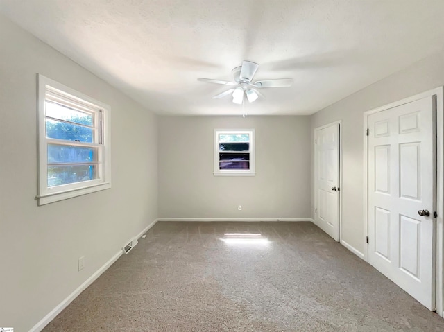 unfurnished bedroom featuring ceiling fan and carpet