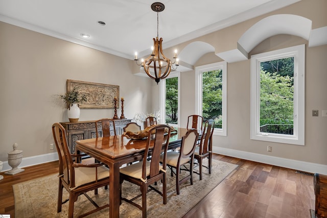 dining area featuring hardwood / wood-style flooring, a chandelier, and ornamental molding