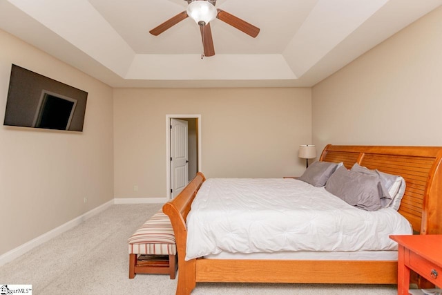 bedroom featuring carpet floors, a raised ceiling, a ceiling fan, and baseboards