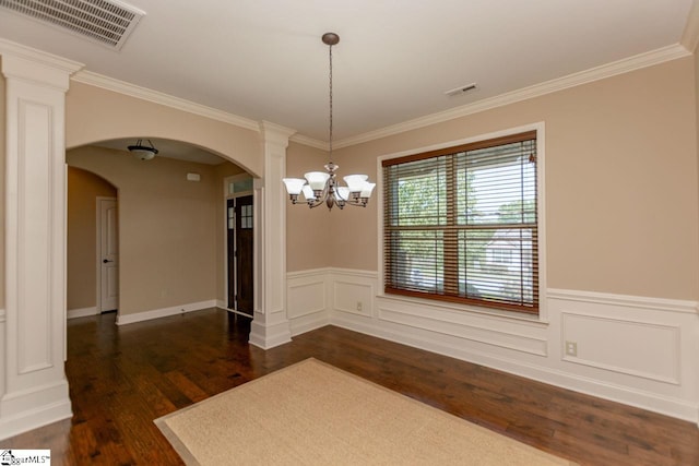 unfurnished dining area with ornate columns, dark hardwood / wood-style floors, an inviting chandelier, and ornamental molding